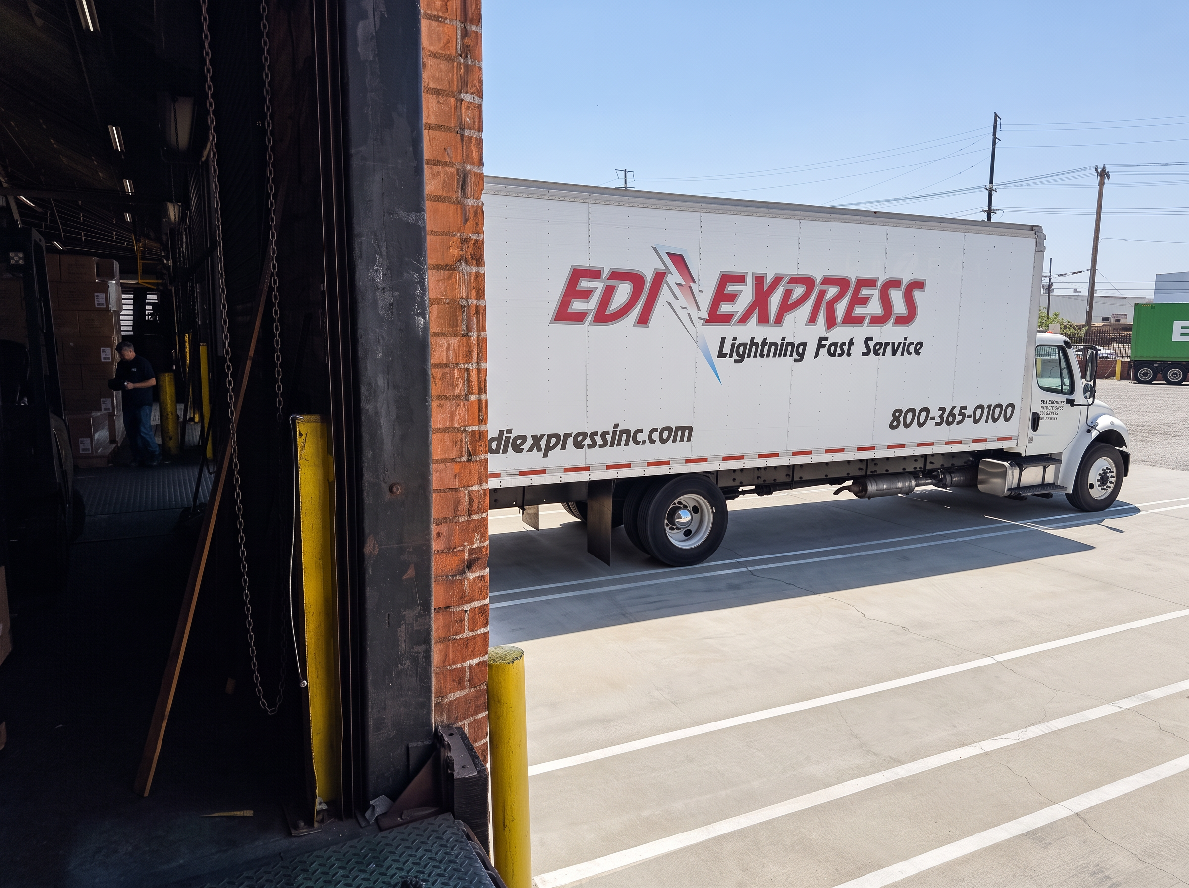 LTL freight pickup at the dock LTL box truck backed into a loading dock door for a freight pickup at Logix Fulfillment in Vernon, California